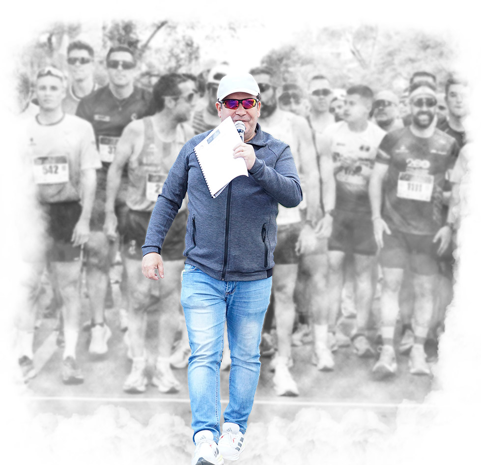 Speaker profesional animando la salida de una carrera popular en Toledo con participantes preparados en línea de salida